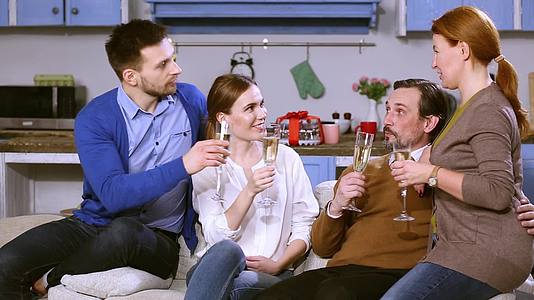 年轻夫妇和女性父母喝香槟他们知道笑声视频的预览图