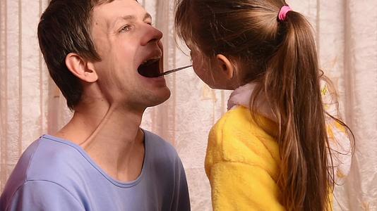 5岁的女儿和父亲扮演医生看喉咙、鼻子和耳朵然后显示视频的预览图