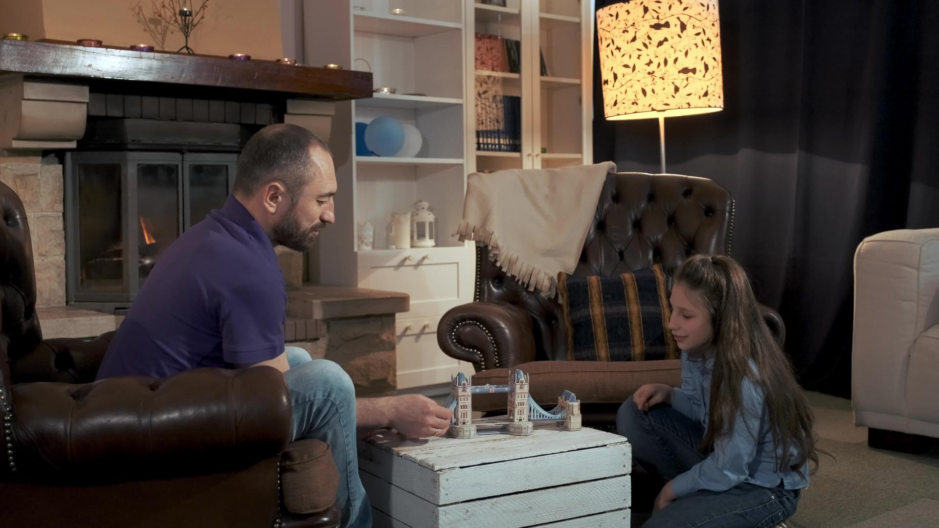 父亲和女儿在客厅壁炉附近享受闲暇时间视频的预览图