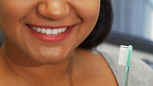 快乐的女士微笑着嘴里戴着牙刷视频的预览图