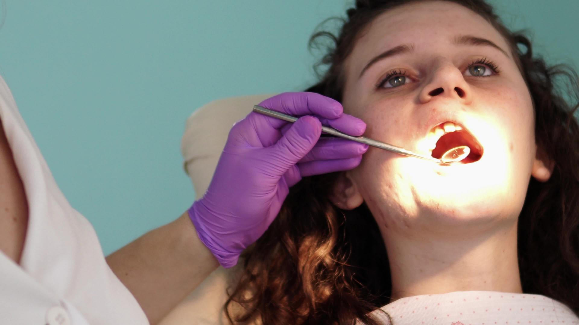 在牙医办公室检查牙齿牙医在牙医椅上检查女孩的牙齿视频的预览图