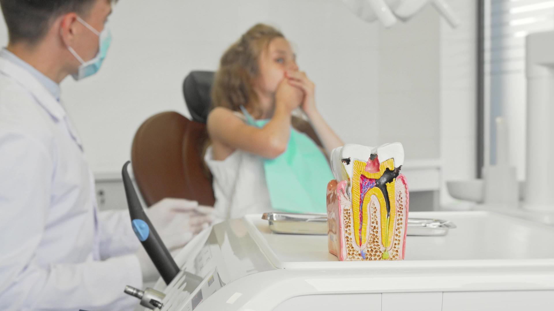 前额牙医与儿童一起工作的不健康牙齿模型视频的预览图