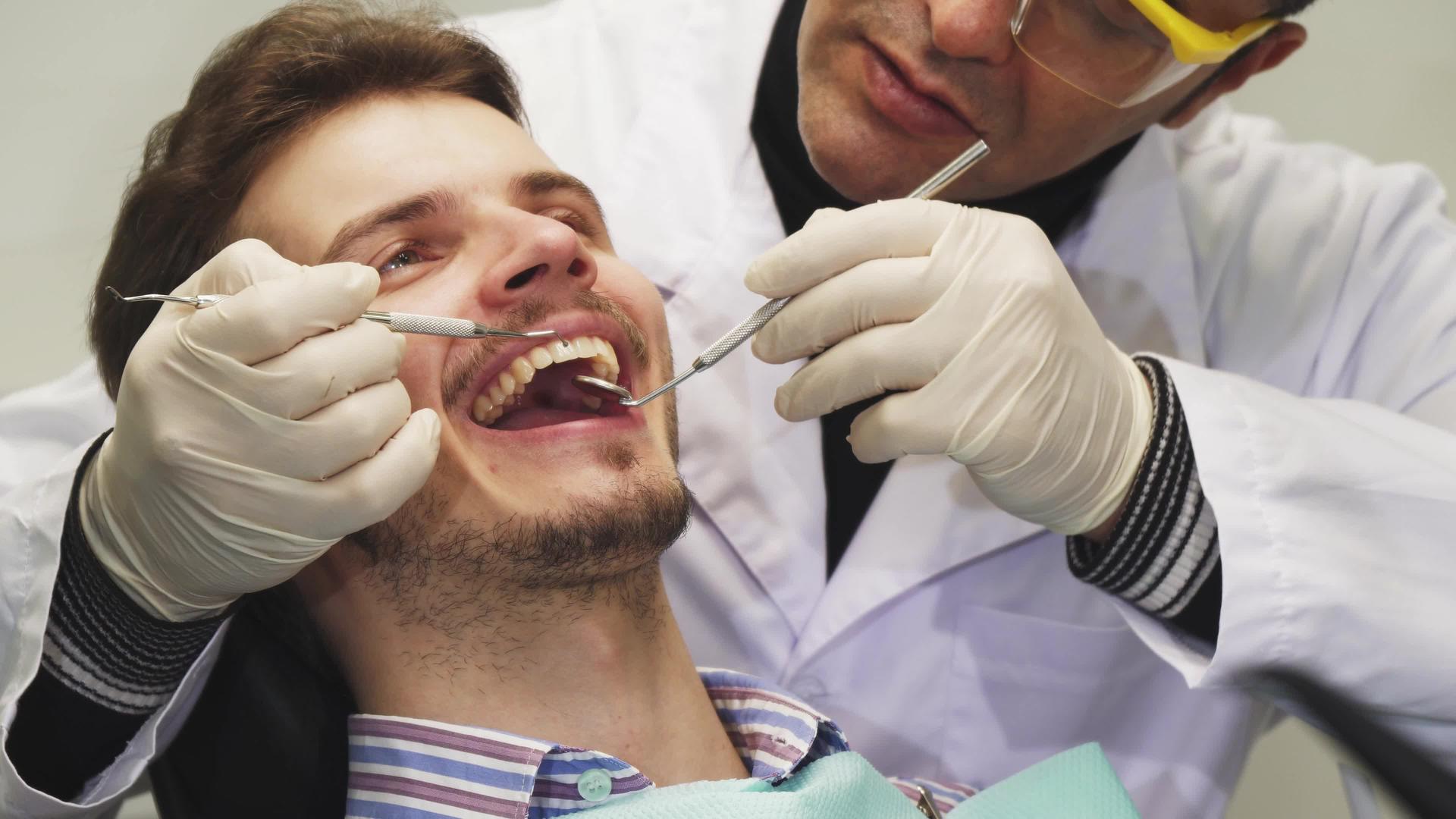 一个英俊的年轻人在牙科检查中微笑视频的预览图