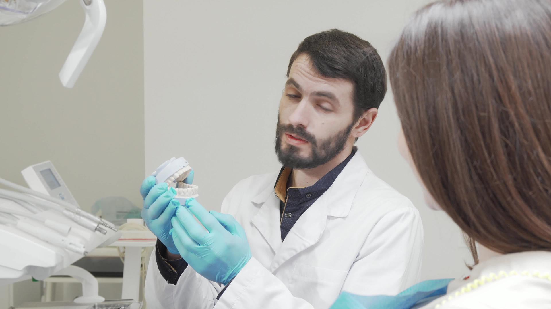 专业牙医在医疗预约期间教育他的女性患者视频的预览图