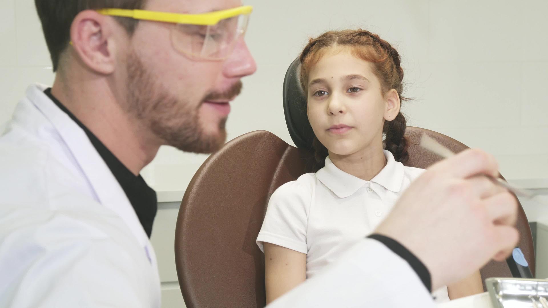 一个善良的医生检查了一个小女孩的牙齿视频的预览图
