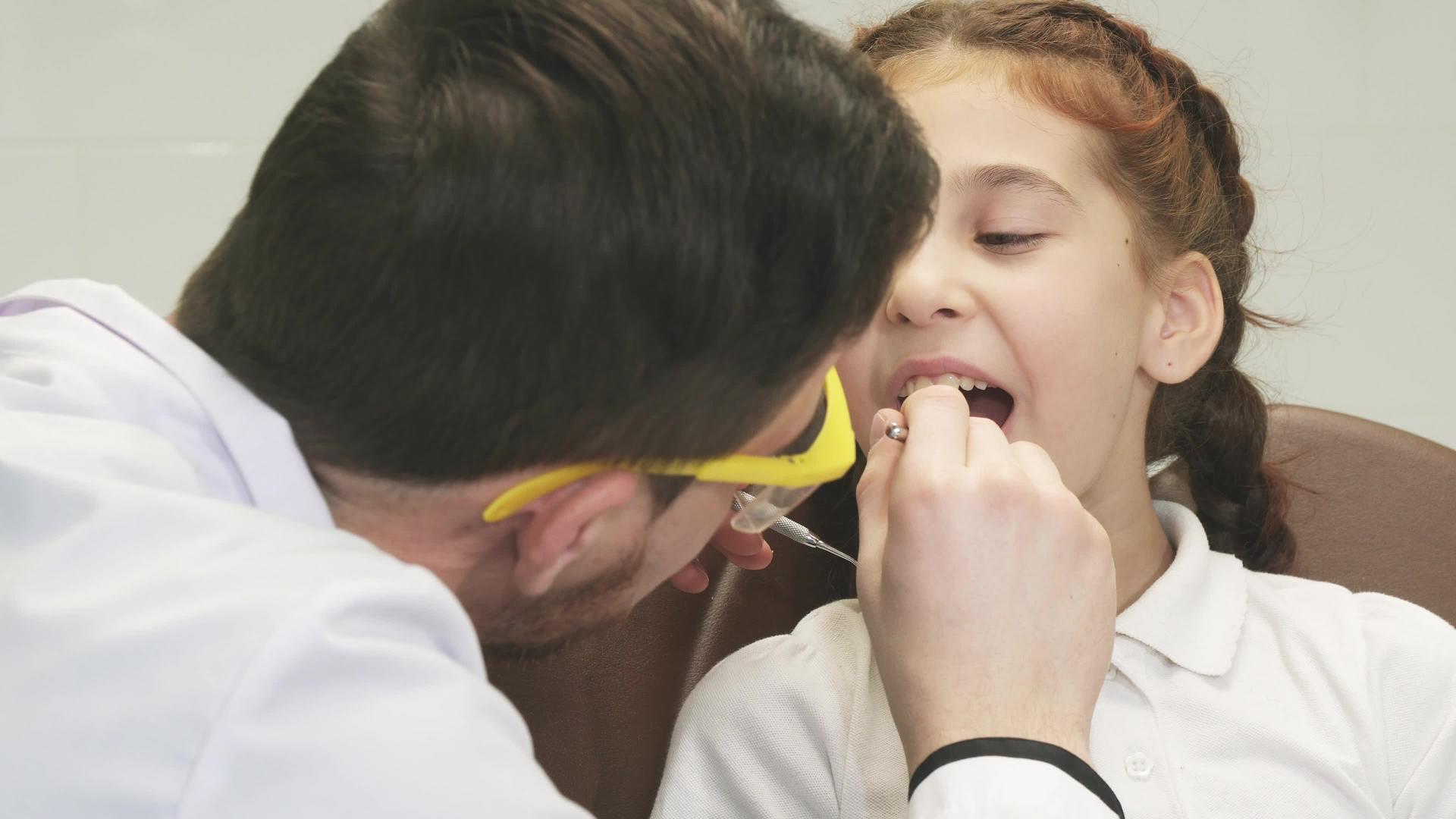 一位专心的牙医检查了他的小病人视频的预览图