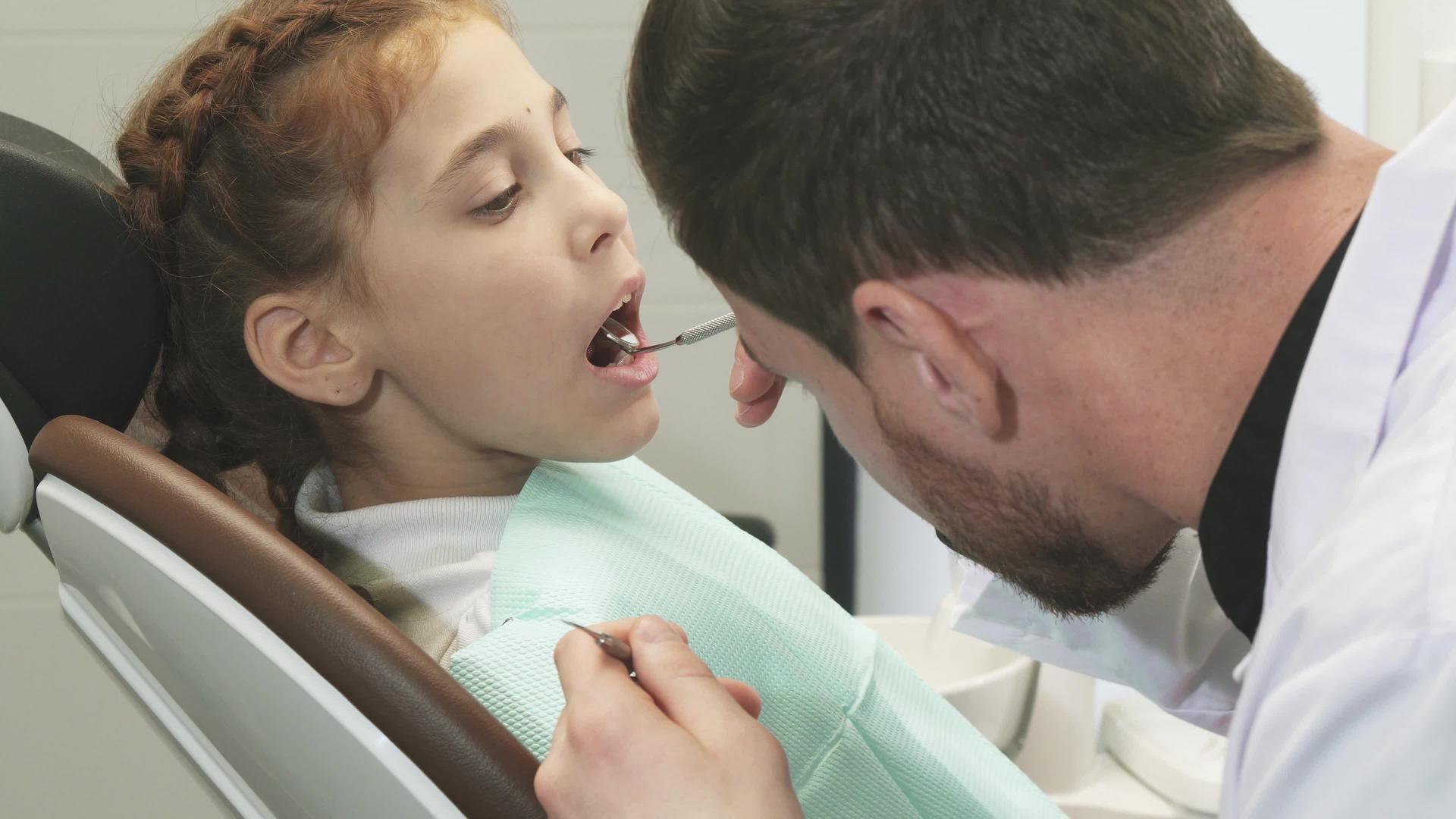 专业医生非常仔细地检查了一个女孩的牙齿视频的预览图