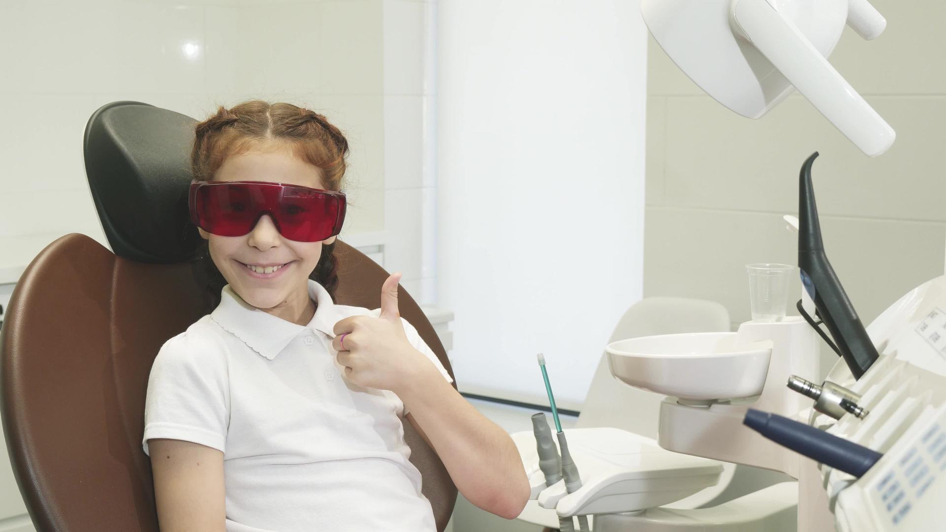 快乐的女孩在牙医招待会上露出了大拇指视频的预览图