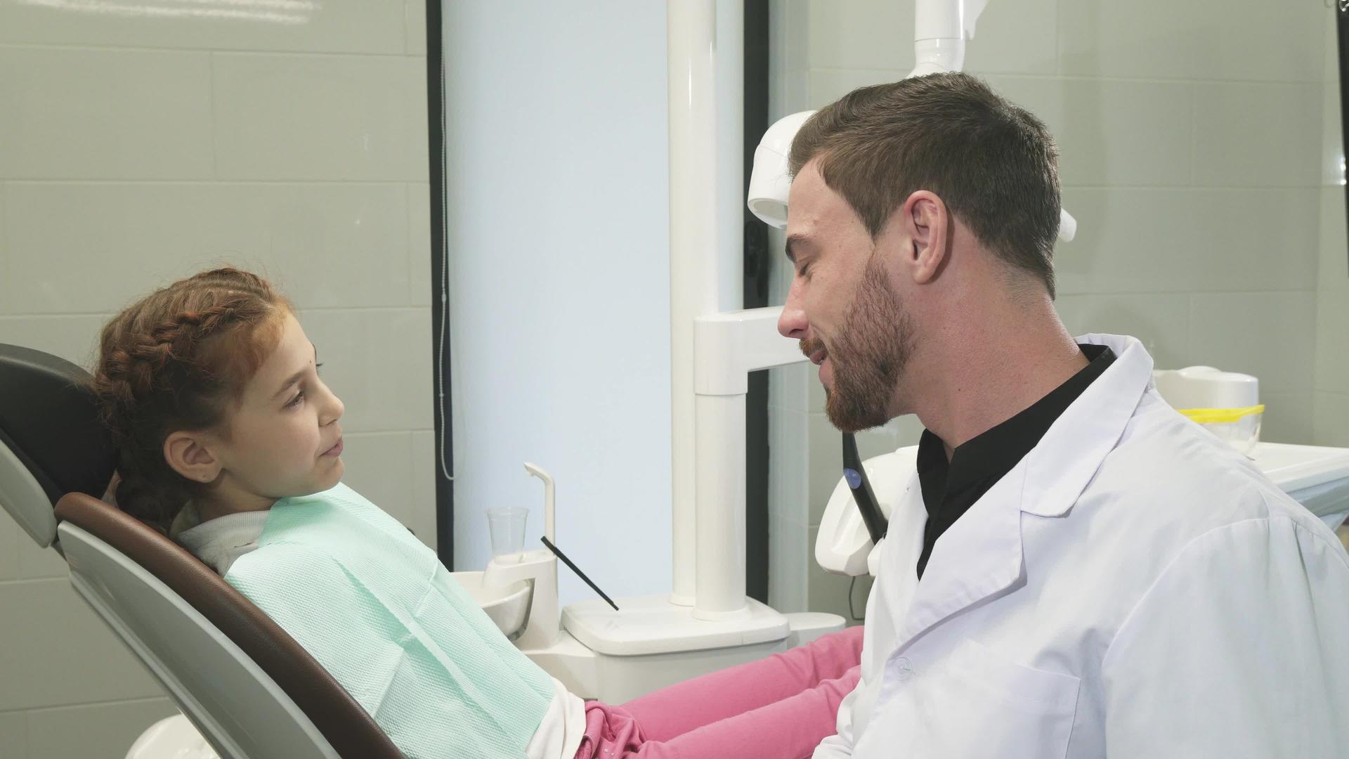 可爱的牙医和他的年轻病人交谈视频的预览图