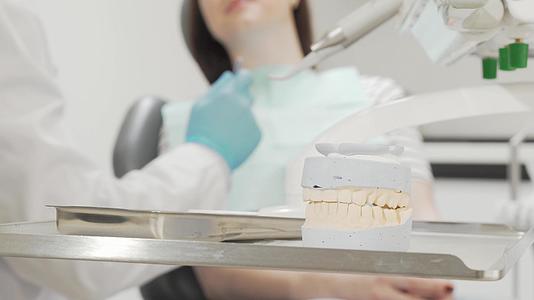 一名牙医在医疗工具桌上的牙科模具被击中视频的预览图