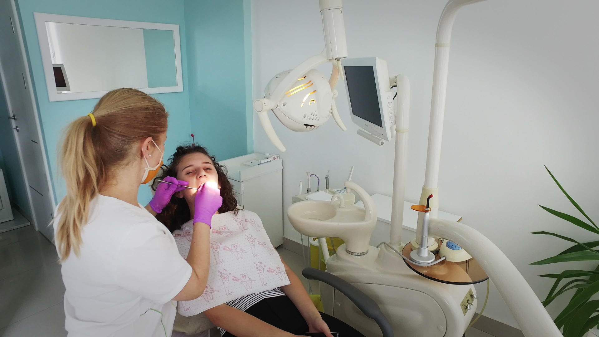 牙医仔细检查了病人女孩的牙齿视频的预览图
