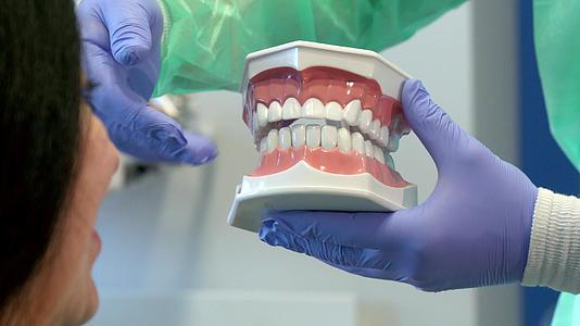 牙医显示顾客的人体牙齿布局视频的预览图