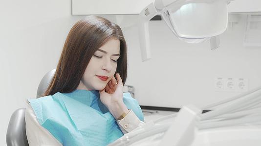 年轻女性坐在牙科椅上牙痛视频的预览图