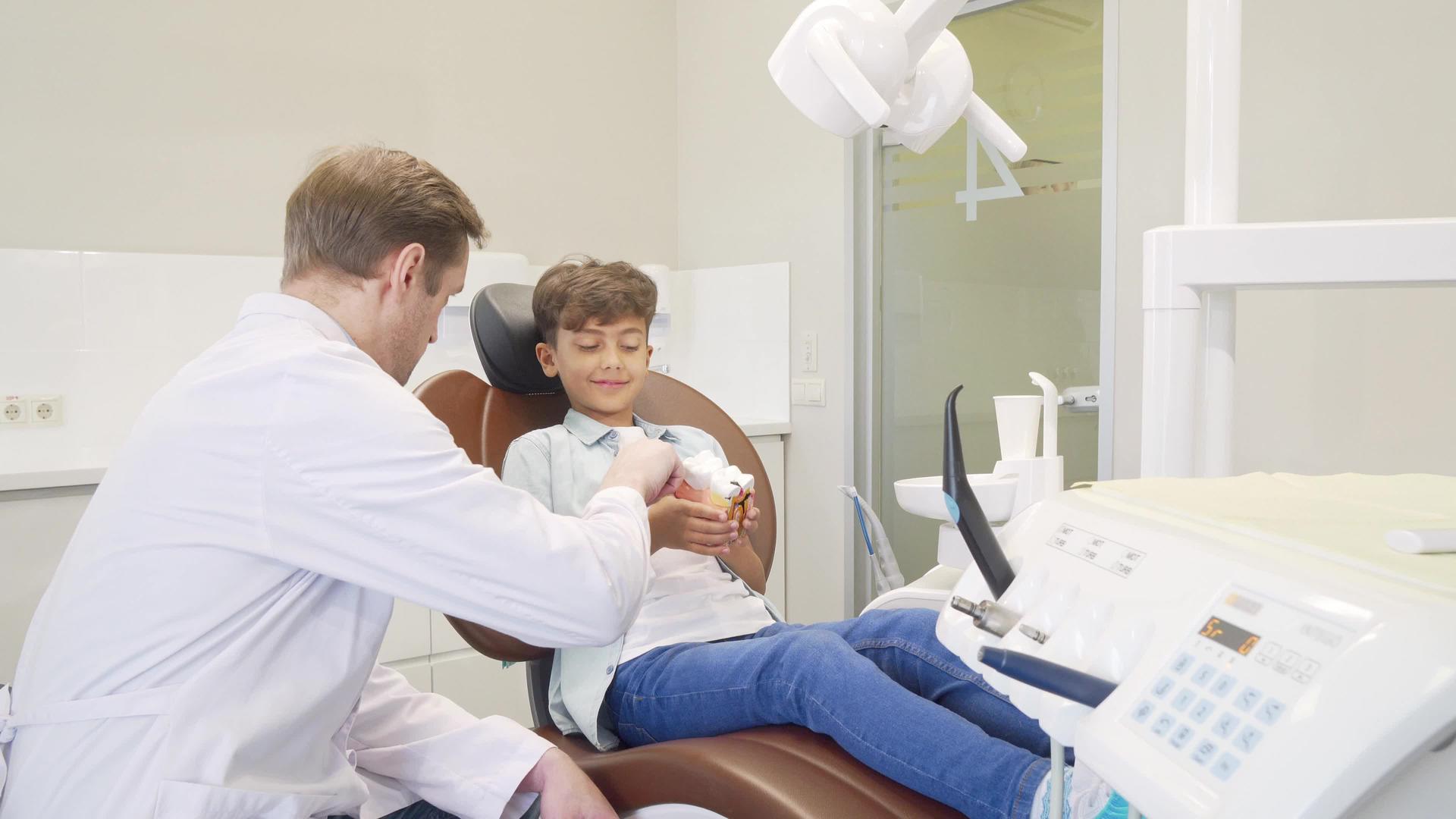 男性牙医教育小男孩关于牙科保健的知识视频的预览图