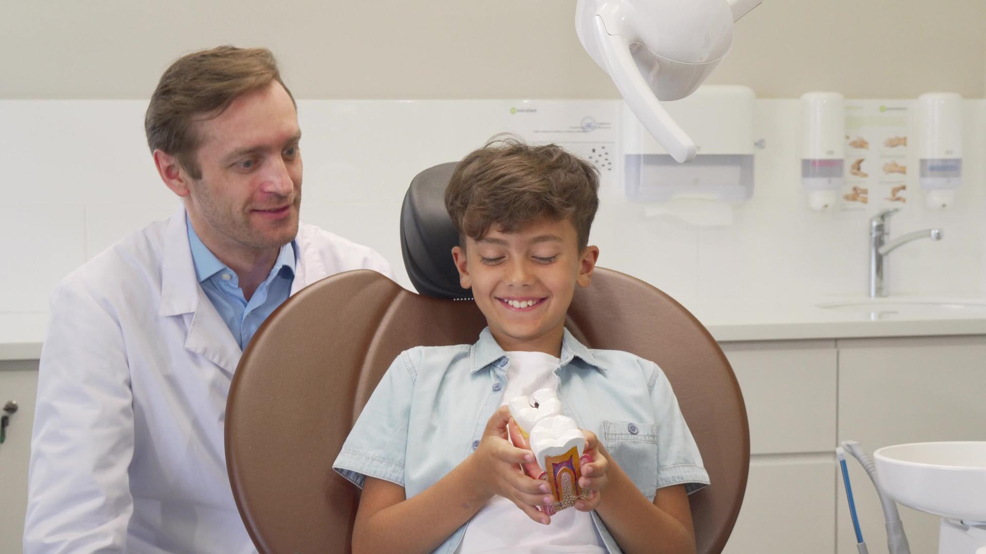 在与牙医成功进行牙科检查后快乐的小男孩露出了拇指视频的预览图