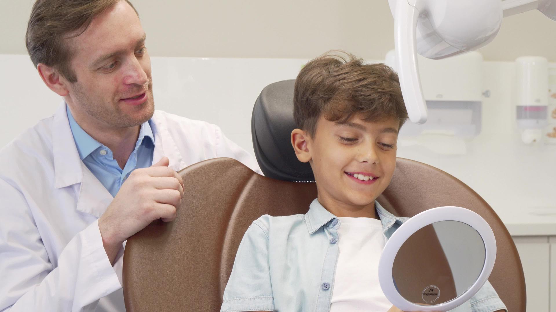 成年男性牙医与迷人的年轻男孩一起工作视频的预览图