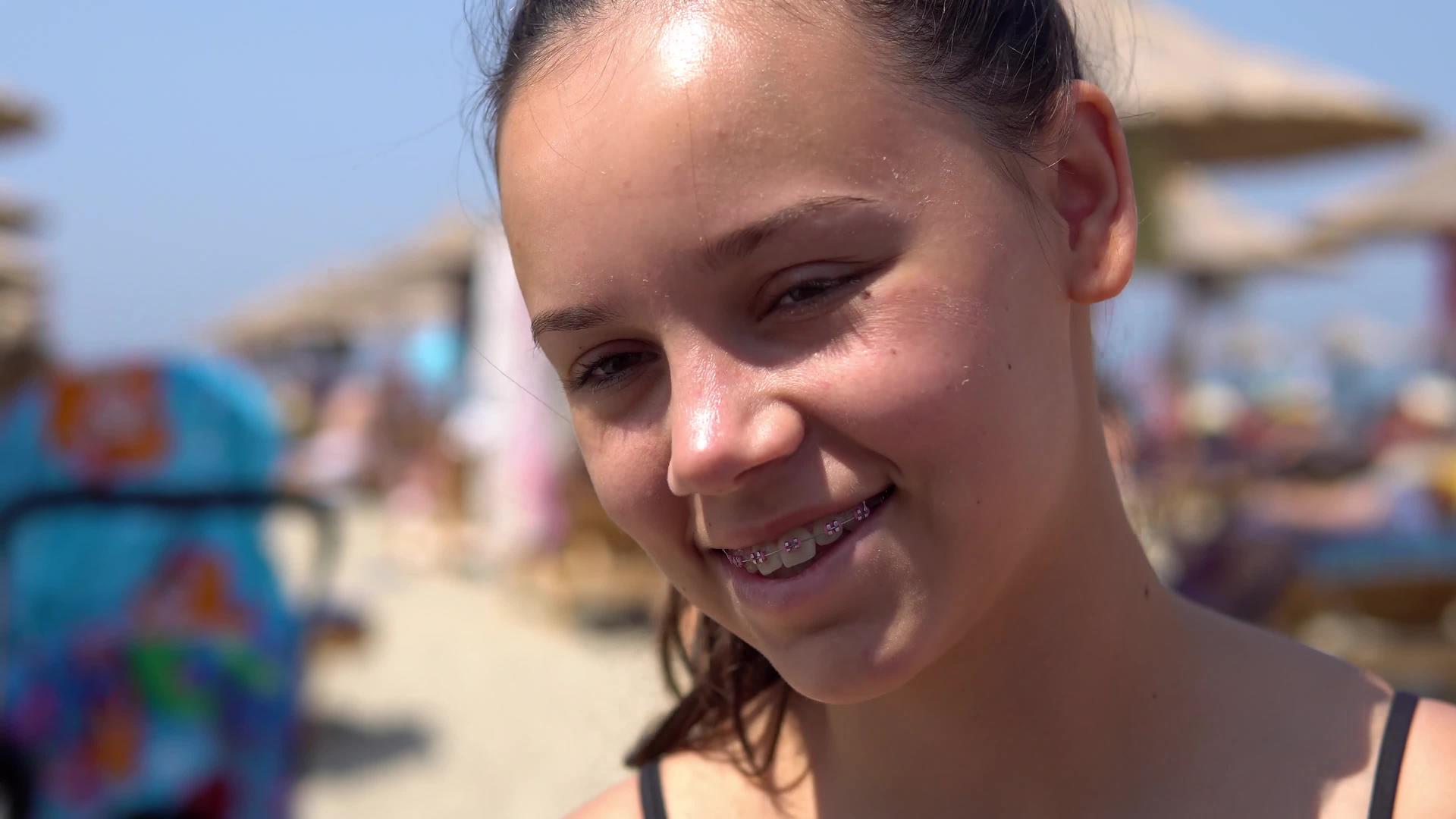 暑假期间坐在海滩上的摄像机前微笑着微笑着视频的预览图
