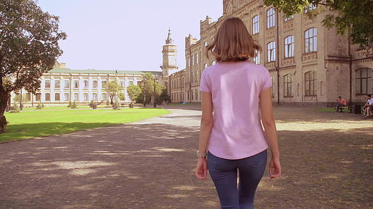 快乐的女人走在大学附近视频的预览图