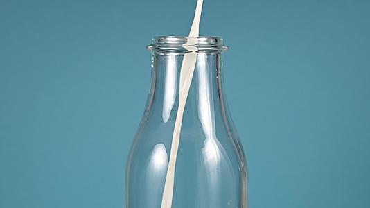 牛奶紧紧地倒在玻璃瓶里视频的预览图