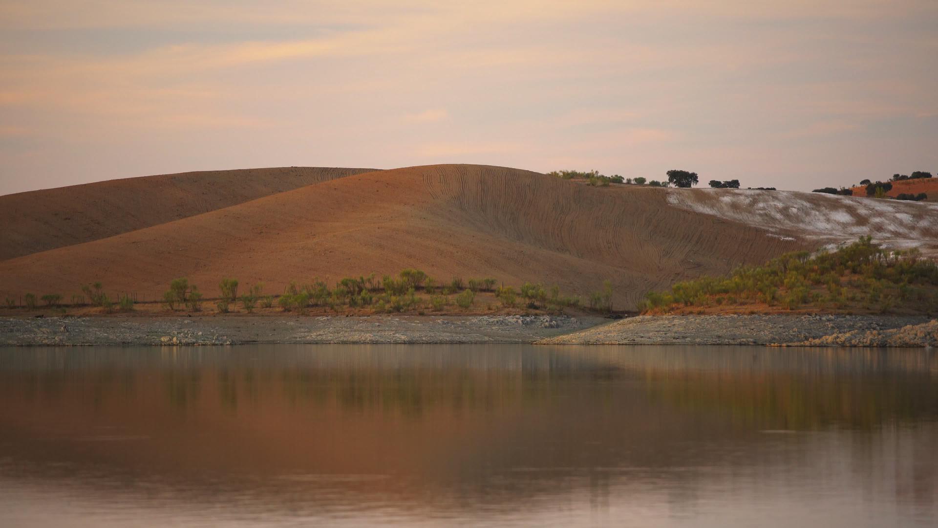 葡萄牙特雷纳日落时分一座大坝湖水库的水面反射沙漠视频的预览图