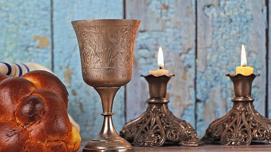 白天和晚上桌子上覆盖着圣杯面包蜡烛和酒杯视频的预览图