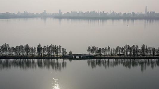 航拍黄昏时分的武汉东湖绿道和城市建筑自然景观视频的预览图