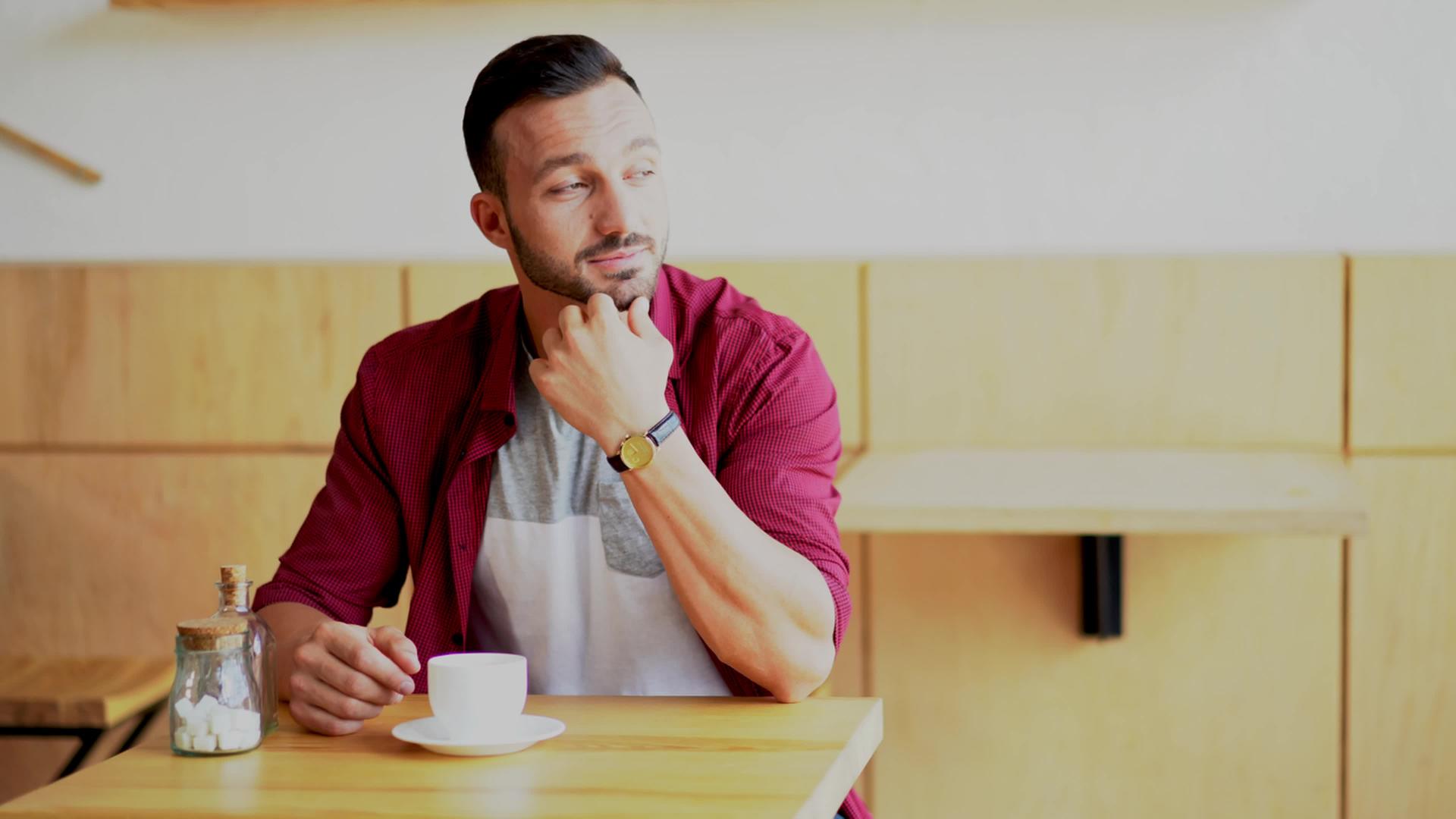 一个英俊的男人坐在咖啡馆里视频的预览图