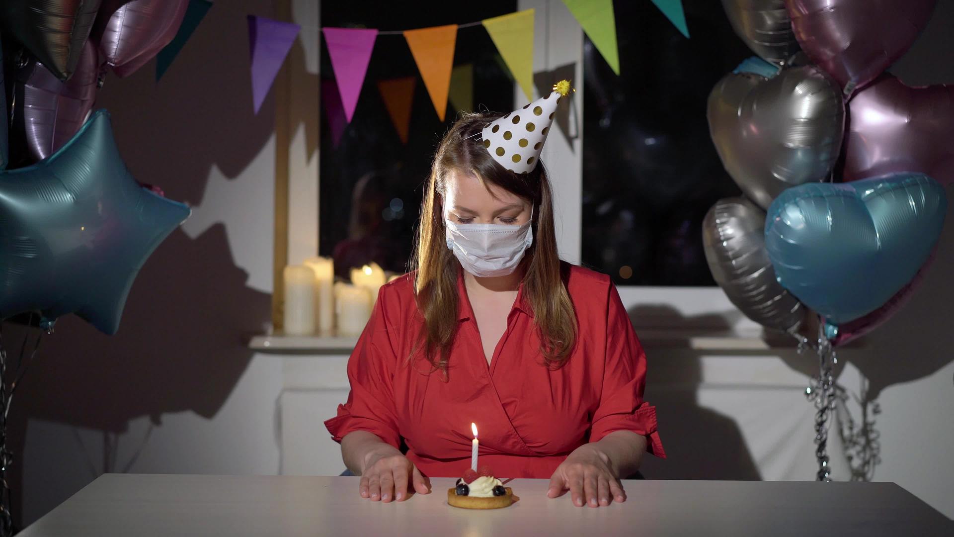 独自庆祝生日的年轻女性戴着带有保护性医疗面具的女孩视频的预览图