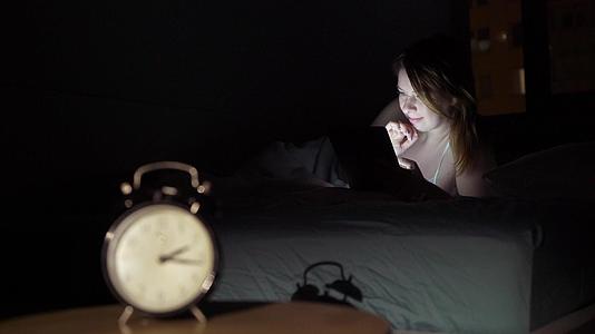 晚上睡在卧室里用智能手机唤醒年轻美女的手机成瘾者视频的预览图