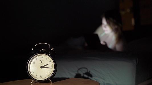 晚上睡在卧室里用智能手机唤醒年轻美女的手机成瘾者视频的预览图