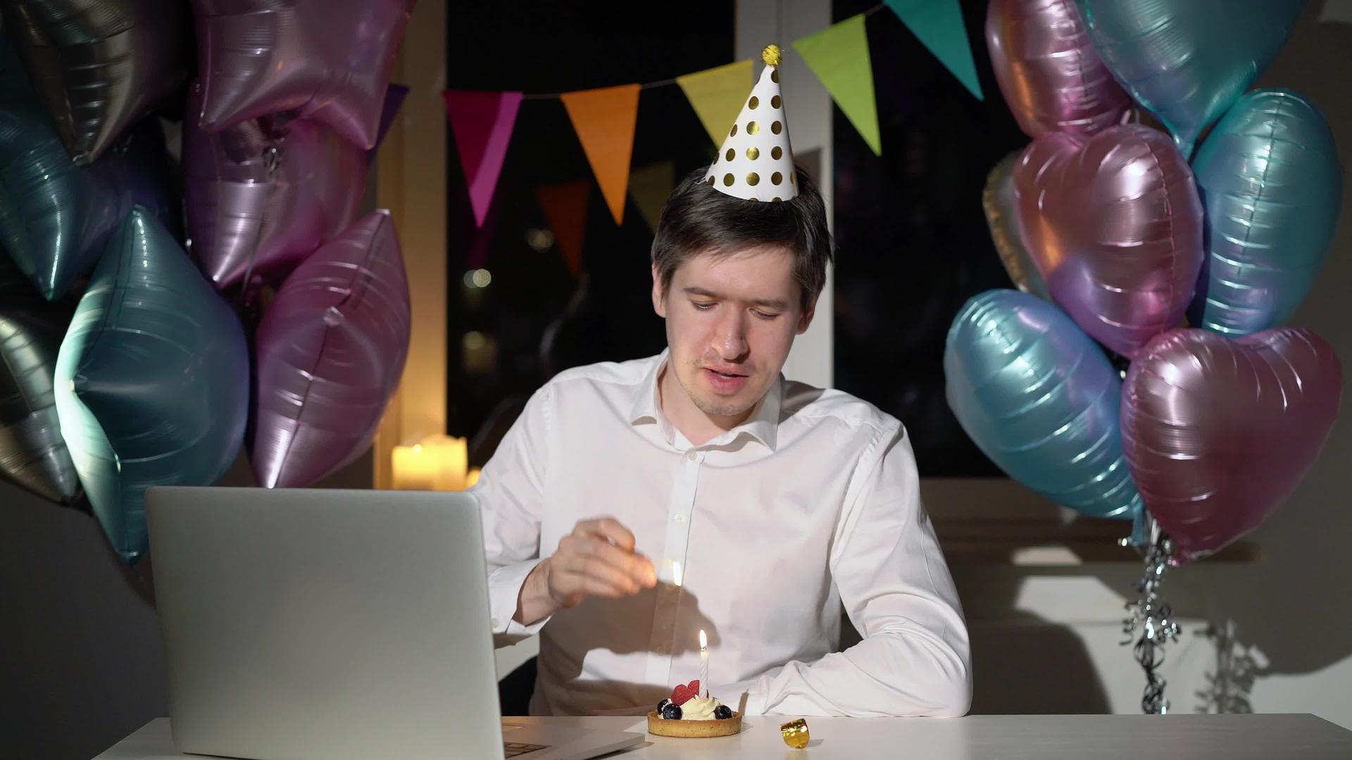 年轻男子用笔记本电脑相机独自庆祝生日视频的预览图