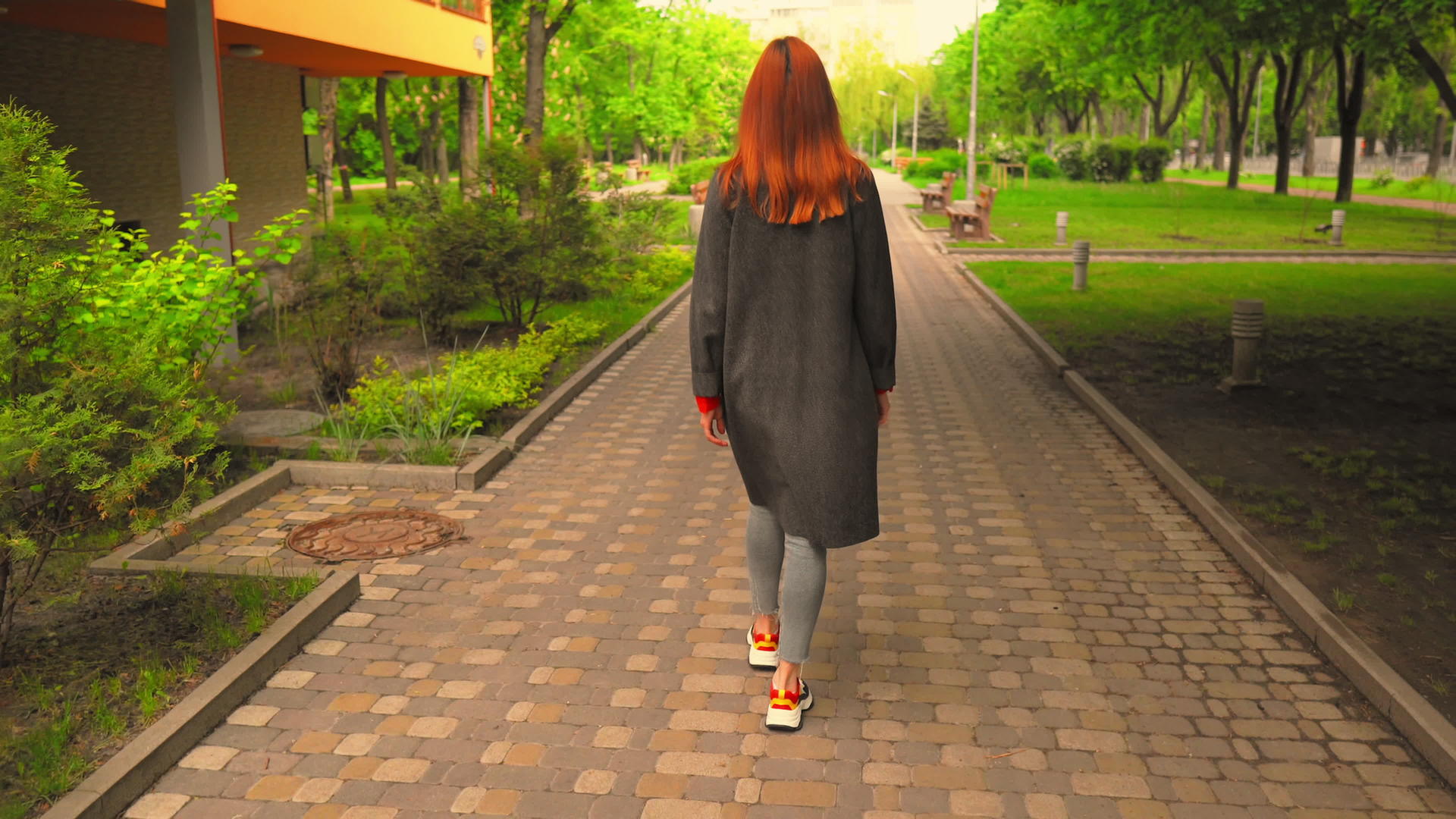 红发女孩在绿色公园散步视频的预览图