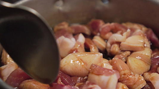 有人用勺子搅拌牛排把猪肉泡在锅里混合棕色酱汁慢慢动作视频的预览图
