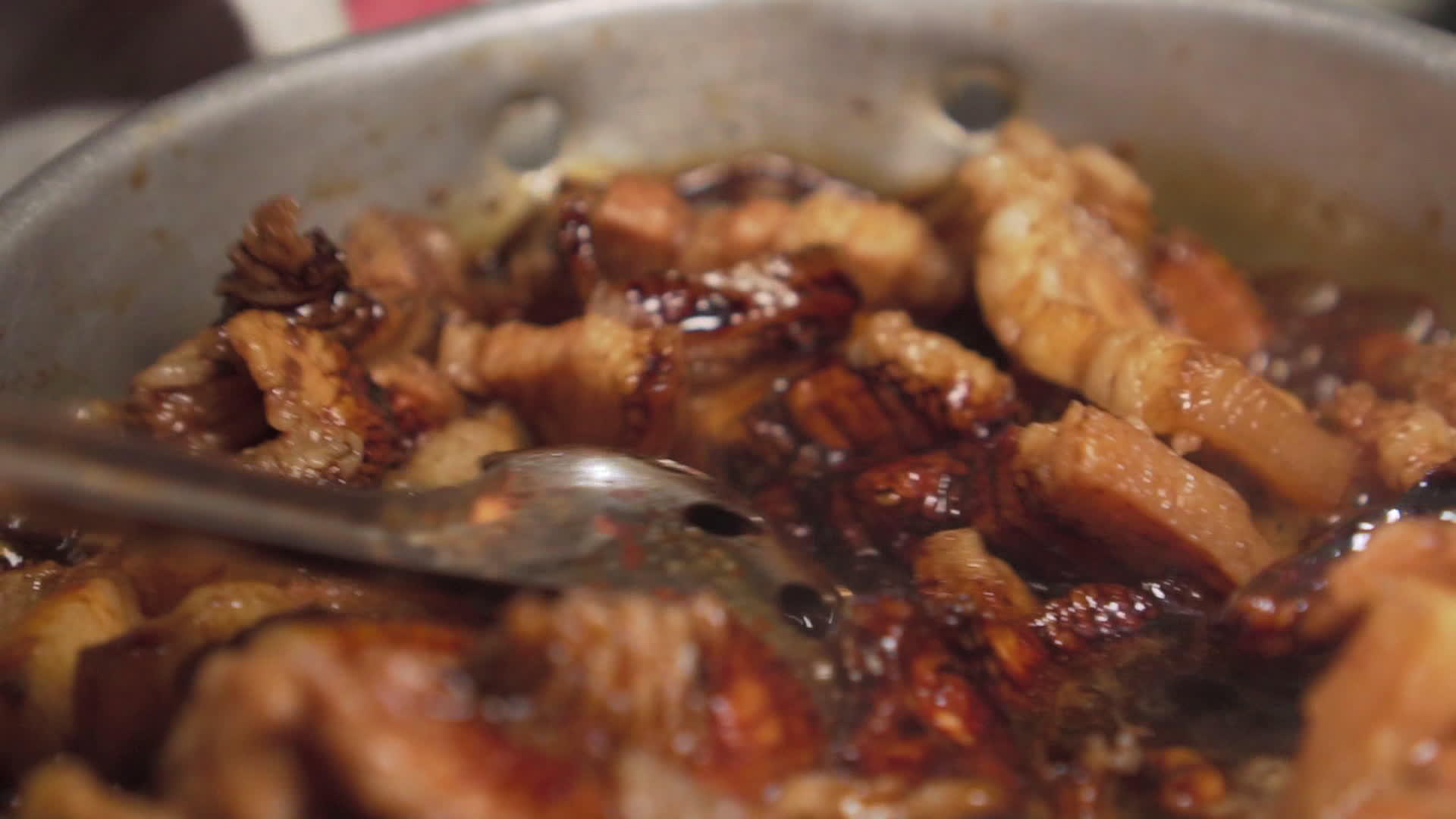 有人用勺子搅拌牛排把猪肉泡在锅里混合棕色酱汁慢慢动作视频的预览图