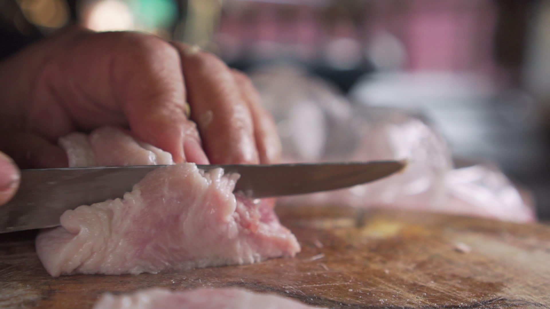 老妇人用刀切生猪肉做饭视频的预览图