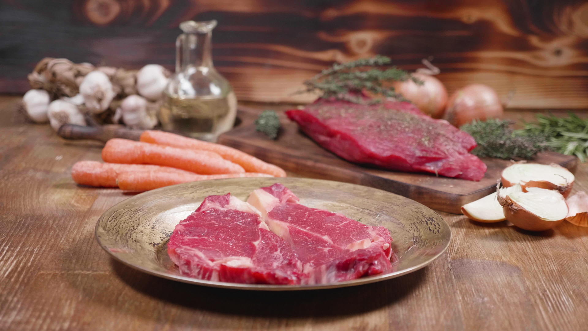 两块生肉和蔬菜的慢速幻灯片以木制背景显示视频的预览图