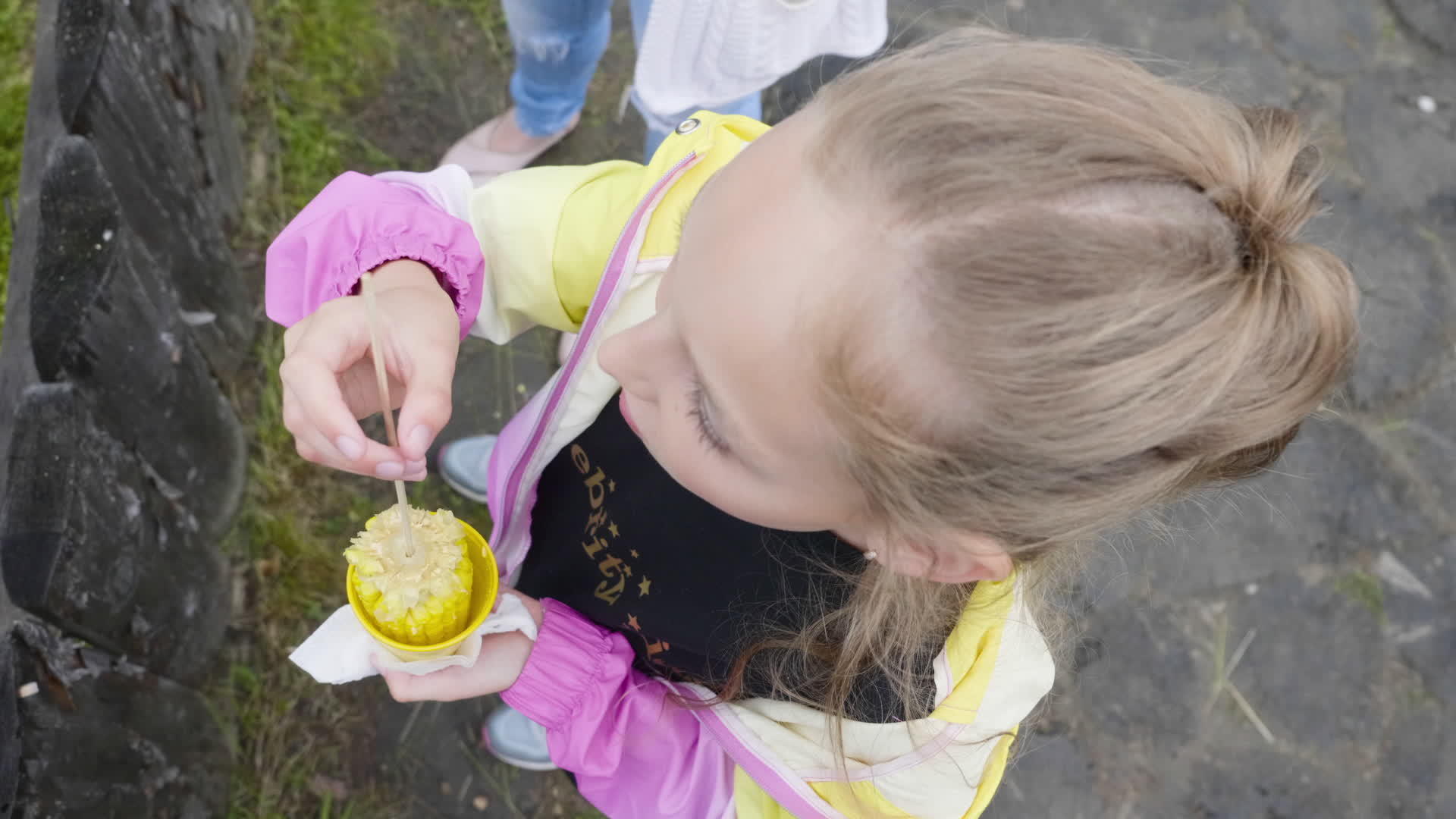 青少年女孩在塑料玻璃上吃玉米在产品的顶部自由食用视频的预览图