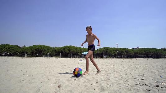 日落时在海滩上玩孩子的乐趣用慢动作踢足球电影视频的预览图