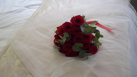 红玫瑰花束新娘的婚礼花束新婚夫妇早上准备卧室的床视频的预览图