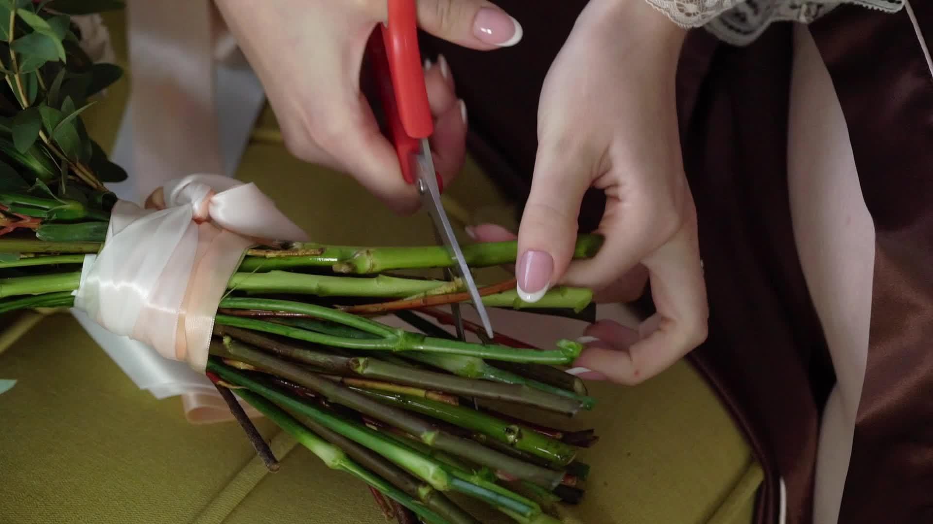 年轻女性用剪刀切玫瑰和红花视频的预览图
