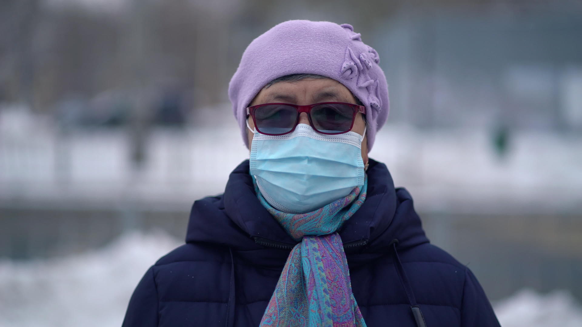 冬季户外使用戴口罩的老年妇女画像视频的预览图