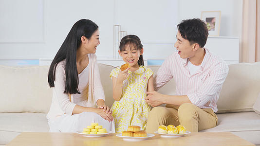 4k中秋节一家三口坐在沙发吃月饼视频的预览图
