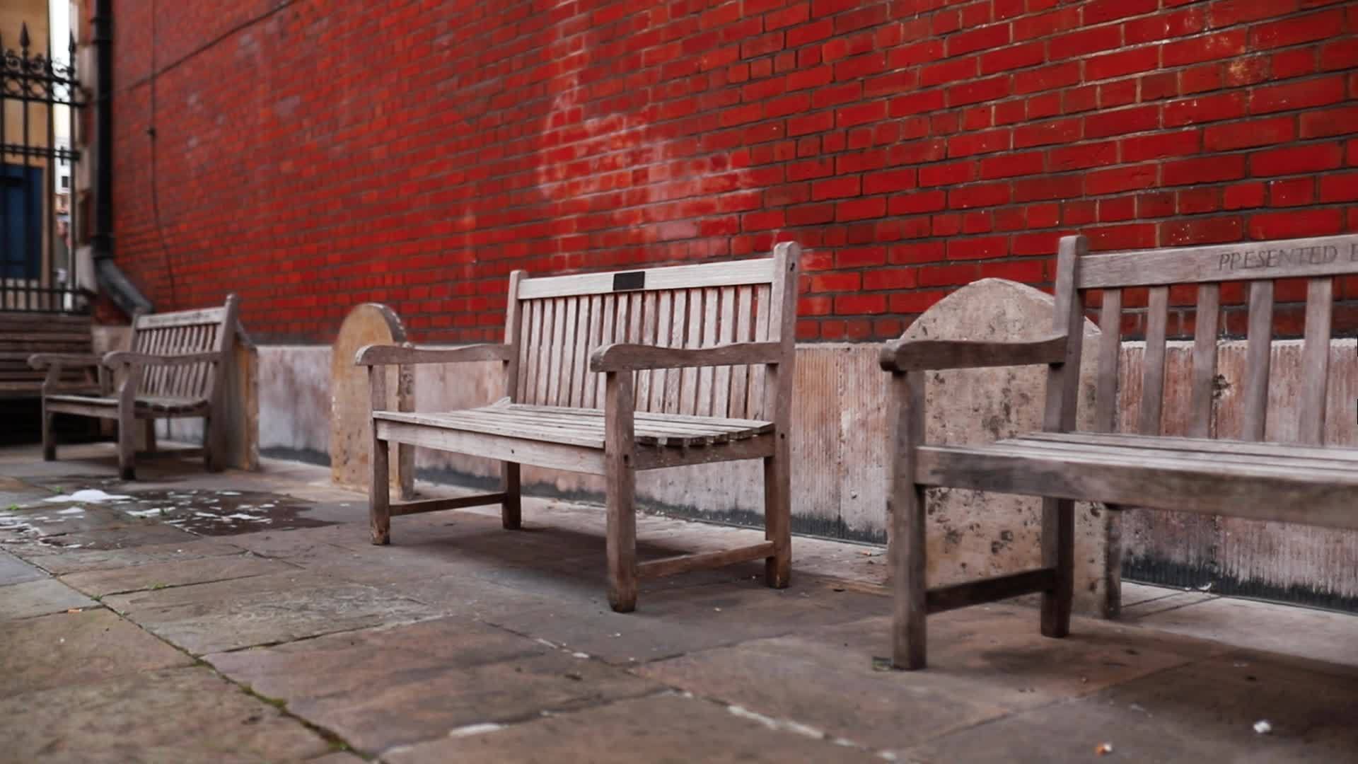 红砖楼外的木凳和墓碑视频的预览图