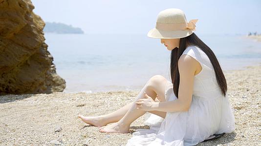 4K美女坐沙滩海边防晒护肤视频的预览图