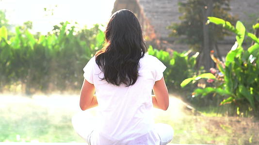 女性在阳光下的温泉池旁做瑜伽视频的预览图