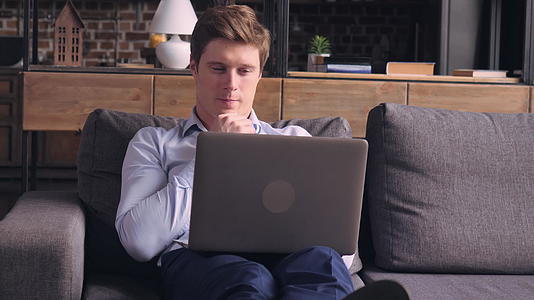 男人在客厅用电脑工作视频的预览图