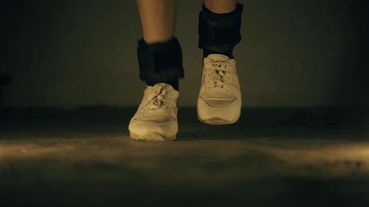 腿部特写镜头穿着白色运动鞋和黑色脚踝重量视频的预览图