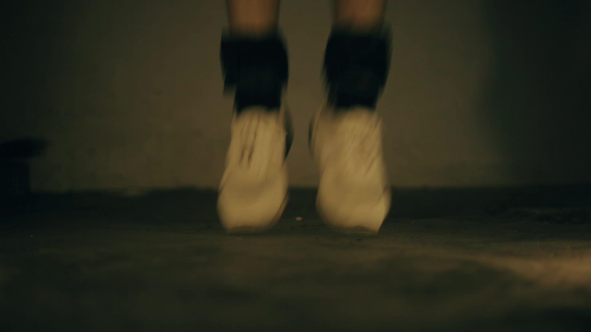穿着白色运动鞋和白色运动鞋和黑色脚踝重量视频的预览图