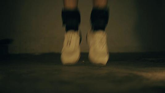 穿着白色运动鞋和白色运动鞋和黑色脚踝重量视频的预览图