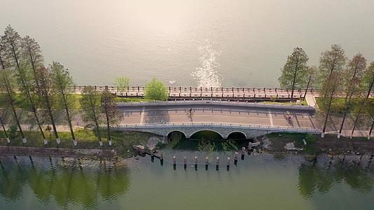 航拍夕阳下的武汉东湖绿道小桥和户外运动的人视频的预览图